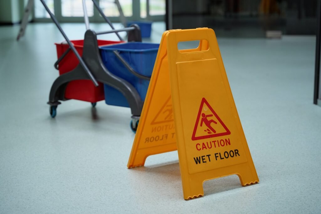 Yellow warning sign about wet floor helping prevent tripping